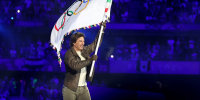 Tom Cruise holds the Olympic flag during the Closing Ceremony of the Olympics, in Paris