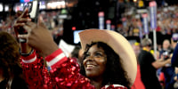 A black woman delegate smiles as she takes a photo at the RNC