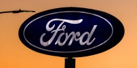 Ford's logo against an orange sky