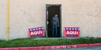 "Vote Here" signs outside library building. 