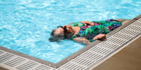 A older woman woman floats in a pool