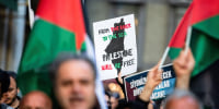 A protester with a sign that  reads "From the river to the sea Palestine will be free" 