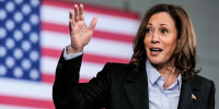 Kamala Harris speaks with hand raised