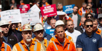 Workers hold signs that read " Nippon Steel = Best Deal for U.S. Steel" and "We want Nippon Steel's Investments"