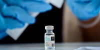 A pharmacist prepares a dose of a vaccine.