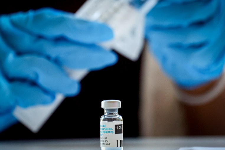 A pharmacist prepares a dose of a vaccine.