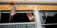 Nicaraguan citizens wave from a bus.